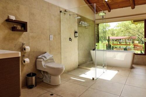 a bathroom with a shower and a toilet and a tub at Ensenada Hotel y Campo Asociado Casa Andina in Cajamarca