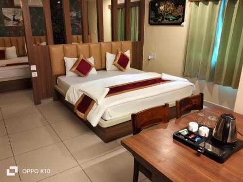 a hotel room with a bed and a table and a table sidx sidx at Hotel ashtha inn in Gaya
