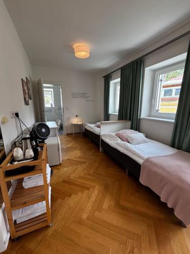 a room with two beds and a desk and two windows at Hotel Villa Rückert in Graz