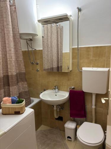 a bathroom with a toilet and a sink and a mirror at Sweet dreams apartment in Bar