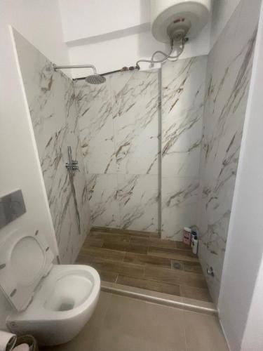 a bathroom with a toilet and marble walls at Blue Door Hideaway in Moutsoúna
