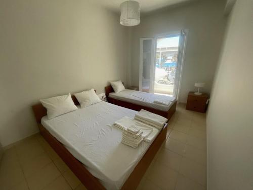 a small bedroom with two beds and a window at Blue Door Hideaway in Moutsoúna