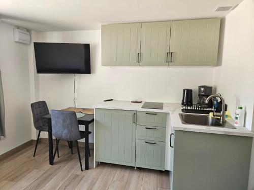 a kitchen with a sink and a table with chairs at Zakątek przy Wydmie in Dziwnów
