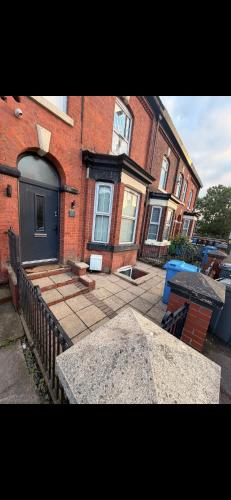 a brick building with a blue door on a street at Hendham Rooms - Near Etihad Stadium, CoOp Live Arena, National Cycling Centre & 24 Hour Asda in Manchester