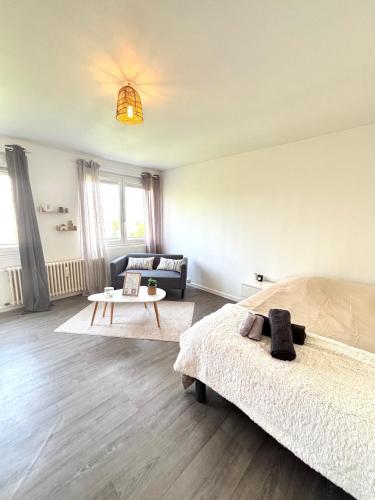 a bedroom with a bed and a living room at Bricks Pérignon - Tram, lit Queen size & air fryer in Chenôve