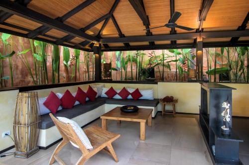 a room with a couch and a table and a fireplace at Alanta Private Pool Villa in Ko Lanta