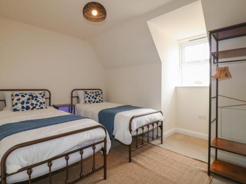 a bedroom with two beds and a window at Stepping Stone in Ashbourne
