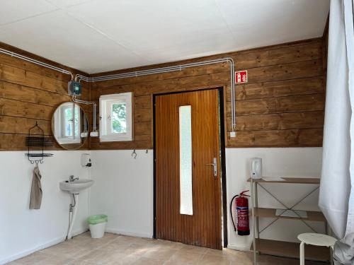 a bathroom with a wooden door and a sink at Gedeon Garden in Budakalász