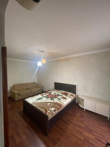 a bedroom with a bed and a couch at Poti apartment in Poti