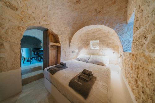 ein Schlafzimmer mit einem Bett in einer Steinwand in der Unterkunft Trullo Cervillo in Cisternino