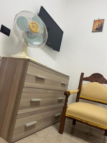 a fan sitting on top of a dresser with a chair at Giardino di Chiara al mare in Torre Rinalda