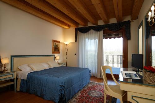 a bedroom with a bed and a desk with a computer at Agriturismo Villa Almè in Oderzo