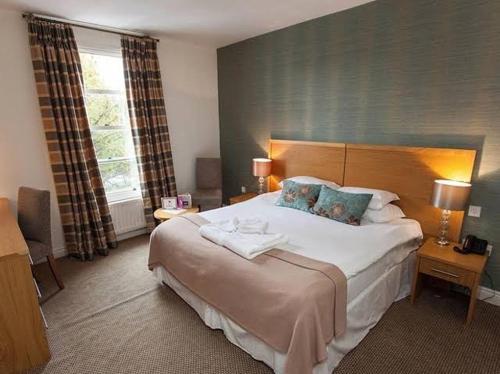 a bedroom with a large bed and a large window at Episode Hotel in Leamington Spa