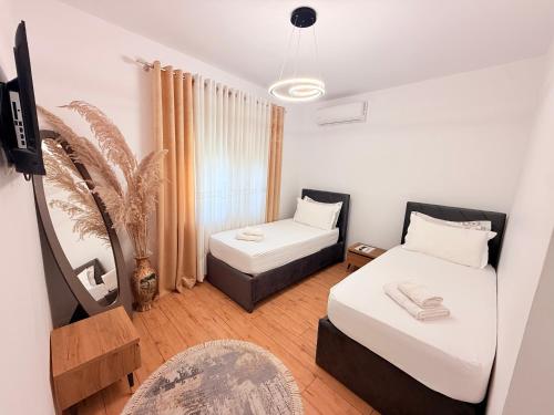 a small room with two beds and a chair at Citrus Nest in Berat