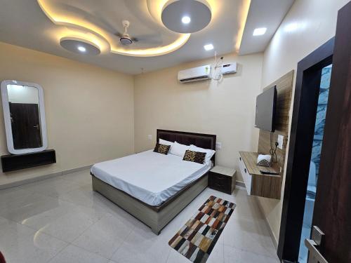 a bedroom with a bed and a flat screen tv at Hotel B Anand in Aonla
