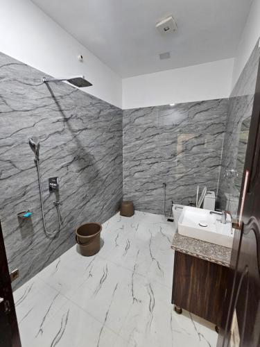 a bathroom with a sink and a shower at Hotel B Anand in Aonla