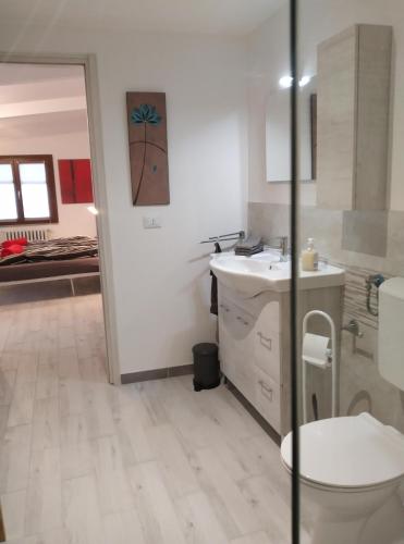 a white bathroom with a toilet and a sink at Casa Doris in Montabone