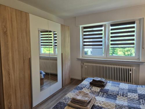 a bedroom with a bed and two windows at FeWo Marjenza in Wermelskirchen