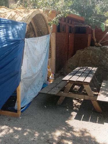a wooden picnic table and a blue tent at مخيم اقشور in Chefchaouen