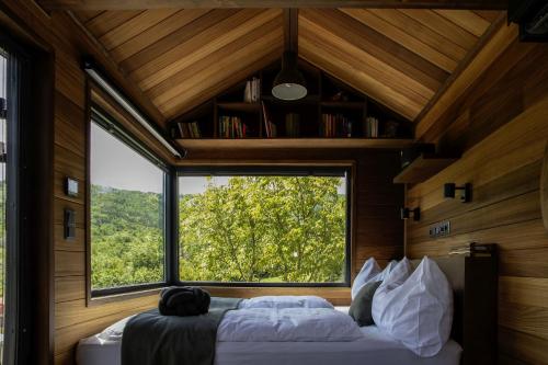 a bedroom with a large window in a house at Gradmina Glamping Retreat in Prevala