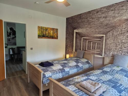 a bedroom with two beds and a brick wall at FeWo Marjenza in Wermelskirchen