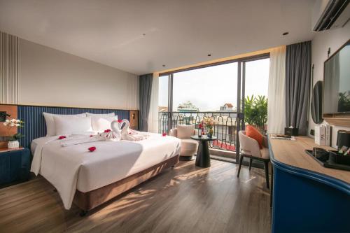 a hotel room with a large bed and a balcony at MAY DE VILLE Prestige Hotel in Hanoi