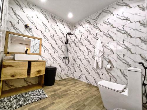 a bathroom with a stone wall with a sink and a toilet at Luxe villa 3 chambres Somone in Somone