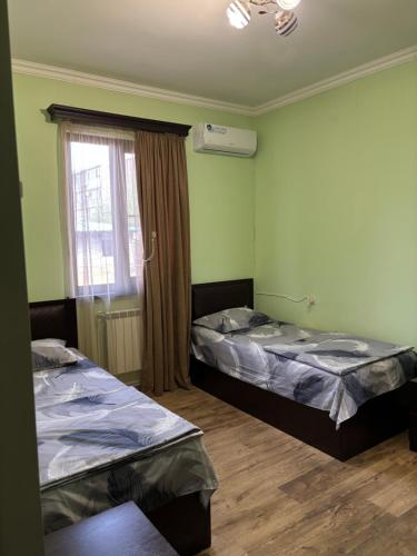 two beds in a room with a window at New , comfortable 3 bedroom house in Yerevan