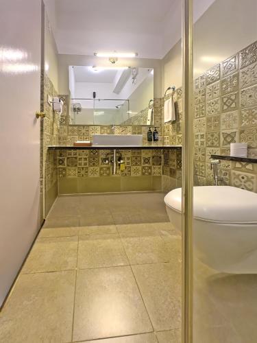 a bathroom with a toilet and a sink at Indo Asia Heritage, Madikeri, formerly Hotel Coorg International in Madikeri