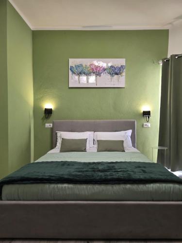a bedroom with a large bed with two paintings on the wall at Isabel House in Capoterra