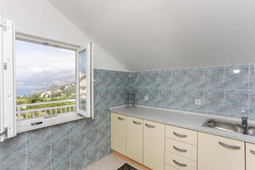 una cocina con fregadero y ventana en Apartments Nada, en Cavtat