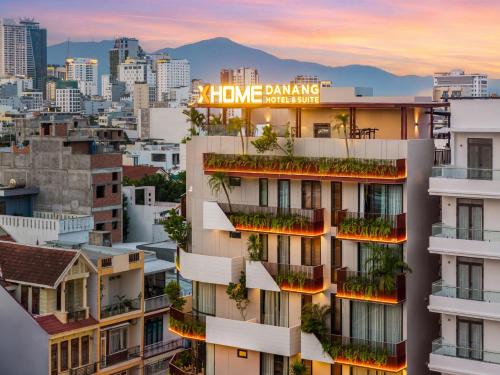 a building with balconies and plants on it with a city skyline at XHOME Danang Hotel & Suite - Near My Khe Beach in Danang