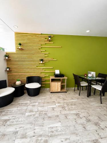 a room with a green wall with a table and chairs at Hotel Campestre Santa Catalina in San Gil