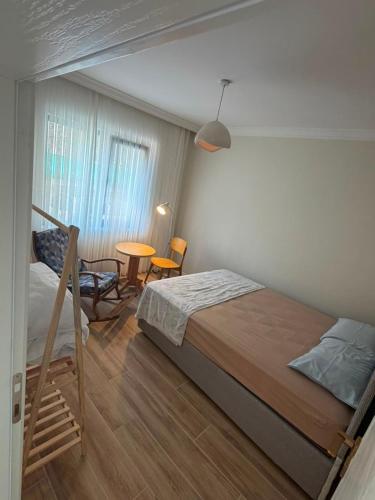 a bedroom with a bed and a table and a chair at Go to Sleep in Gelibolu