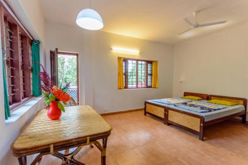 a living room with a bed and a table at BASIS Mountain House in Thekkady