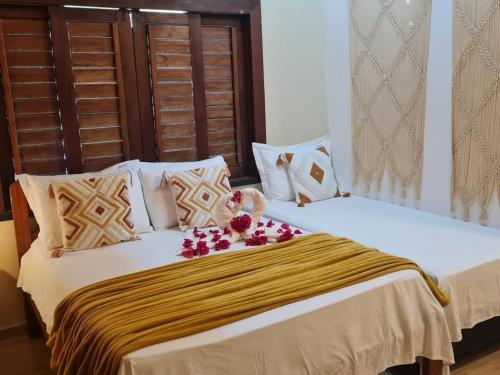 a bedroom with two beds with flowers on them at Chalé Jacuzzi Fortim in Fortim