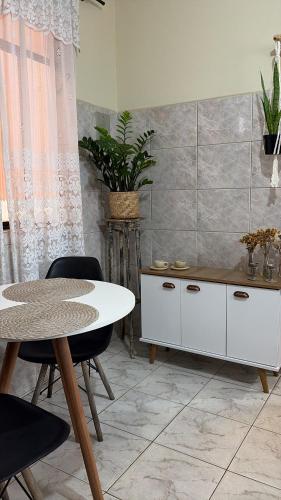 a dining room with a table and a white cabinet at Mini Casa Tiradentes 2 in Tiradentes