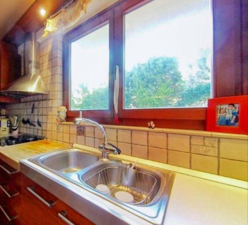 a kitchen with a sink and two windows at Ta'Casa in Xàtiva