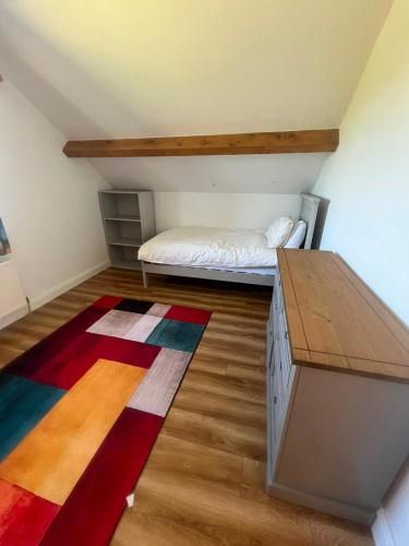 a attic room with a bed and a rug at Hackettstown in Ardmore