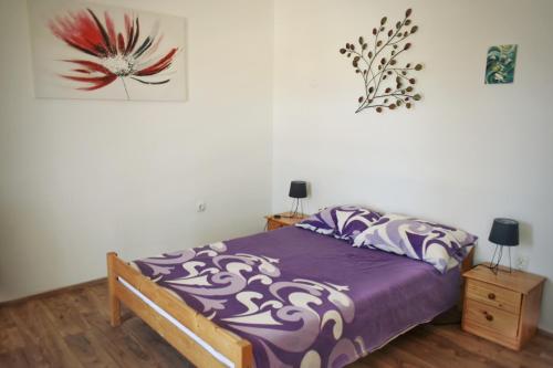 a bedroom with a purple bed and two night stands at Agava in Lovište