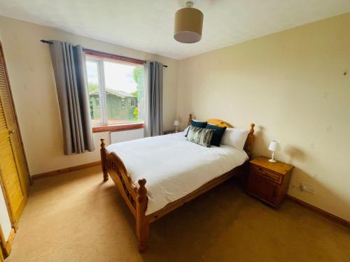 a bedroom with a large bed and a window at Tigh-na-lios, Inver in Inver