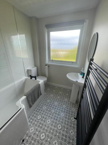 a bathroom with a tub and a toilet and a sink at Tigh-na-lios, Inver in Inver