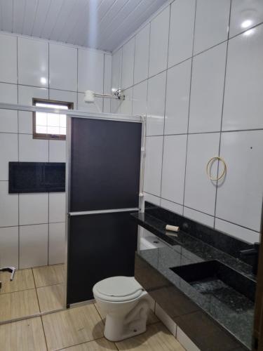 a bathroom with a toilet and a black counter at KmX in Campo Grande