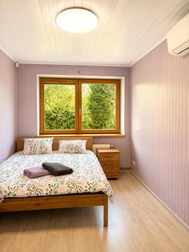 a bedroom with a bed and a window at Flower 18 in Jūrmala