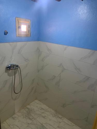 a bathroom with a shower with a window in it at Desert Tours & Camp Chraika in Mhamid