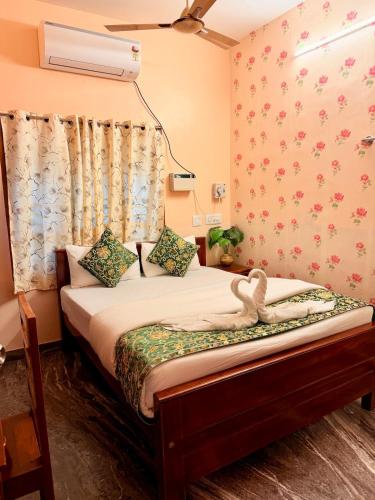 a bedroom with a bed with a swan on it at Blue home stay- 10min walk to kanyakumari beach in Kanyakumari