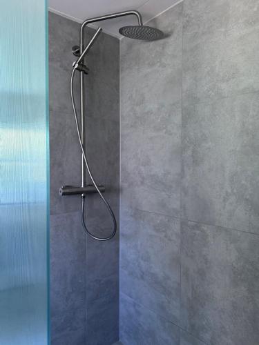 a shower with a shower head in a bathroom at Tønder Byhus in Tønder