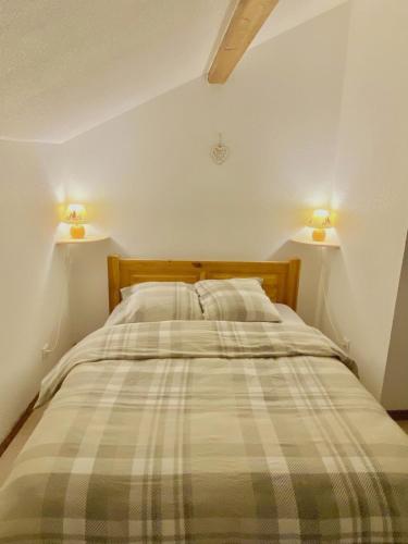 a bedroom with a bed with two lamps on the wall at Le Bellevue in Xonrupt-Longemer
