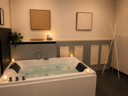 a bathroom with a bath tub with candles in it at Wellness Suite Zeist in Zeist