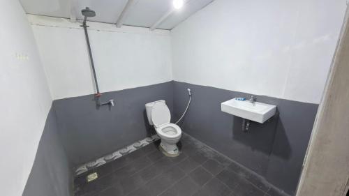 a bathroom with a toilet and a sink at Bintang Left Homestay Mentawai in Katiet